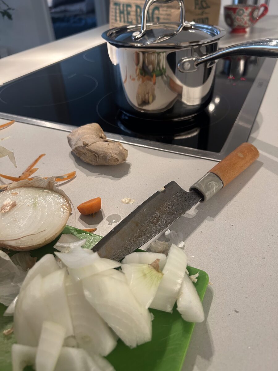 Butternut squash, onion, garlic, ginger, and spices laid out on a cutting board